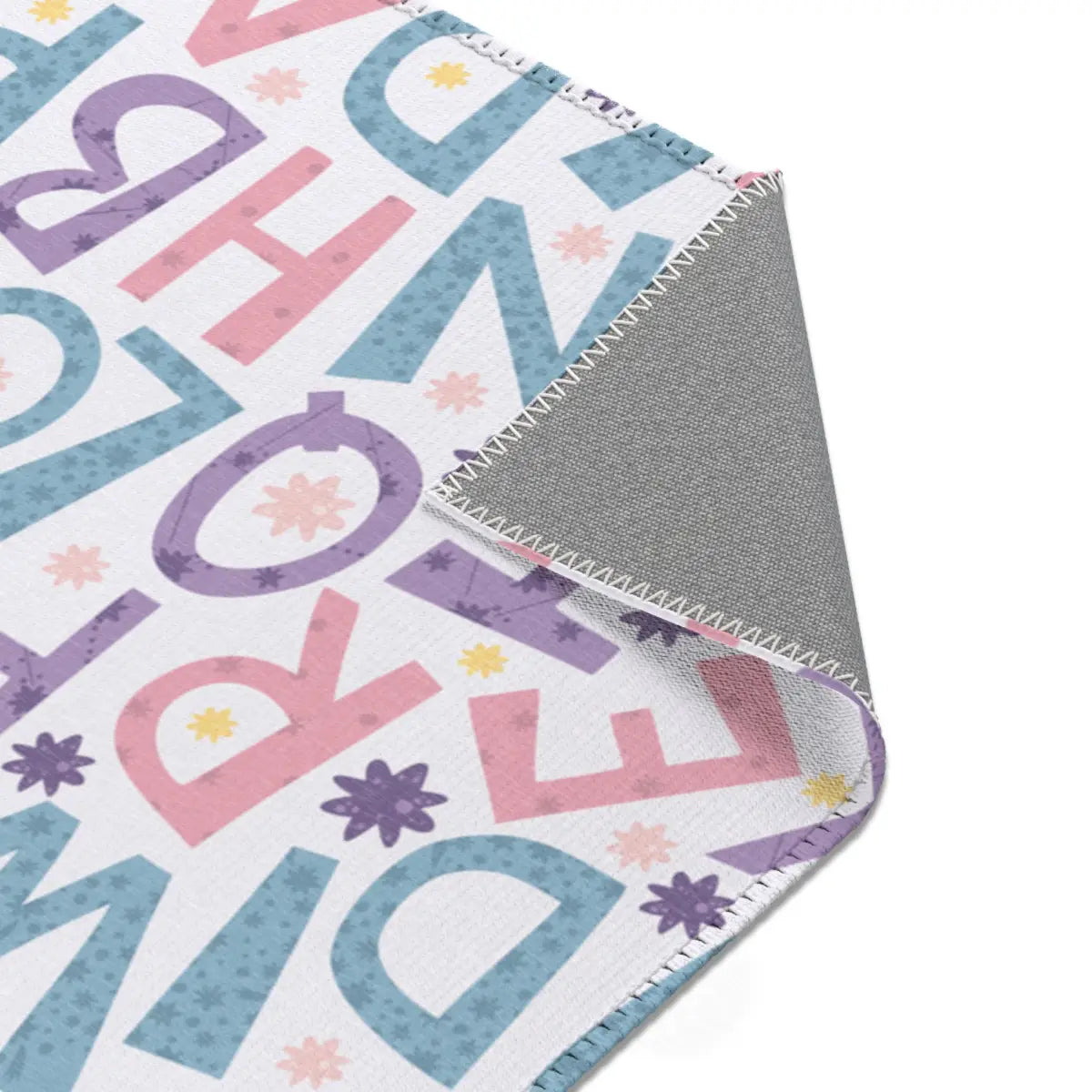 Kinderteppich "Buchstabensalat" von spielzwerg. Nahaufnahme umgeklappte Ecke. RUG-00115-XL, RUG-00115-L.