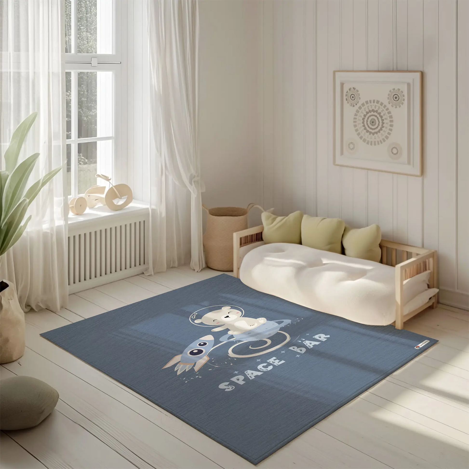 Kinderteppich "Space Bär" von spielzwerg. Ambientebild von einem hellen, freundlichen Kinderzimmer mit weißen Holzwänden und hellem Holzboden. In der Ecke steht ein niedriges Holzbett mit weißen Decken und hellgrünen Kissen. Davor liegt der Teppich. Links steht ein kleines Holzspielzeugrad am Fenster mit weißen Vorhängen. An der Wand hängt ein gerahmtes Bild mit einem dezenten, kreisförmigen Muster. RUG-00048-XL, RUG-00048-L.