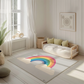 Kinderteppich "Bunter Regenbogen" von spielzwerg. Ambientebild von einem hellen, freundlichen Kinderzimmer mit weißen Holzwänden und hellem Holzboden. In der Ecke steht ein niedriges Holzbett mit weißen Decken und hellgrünen Kissen. Davor liegt der Teppich. Links steht ein kleines Holzspielzeugrad am Fenster mit weißen Vorhängen. An der Wand hängt ein gerahmtes Bild mit einem dezenten, kreisförmigen Muster. RUG-00204-XL, RUG-00204-L.