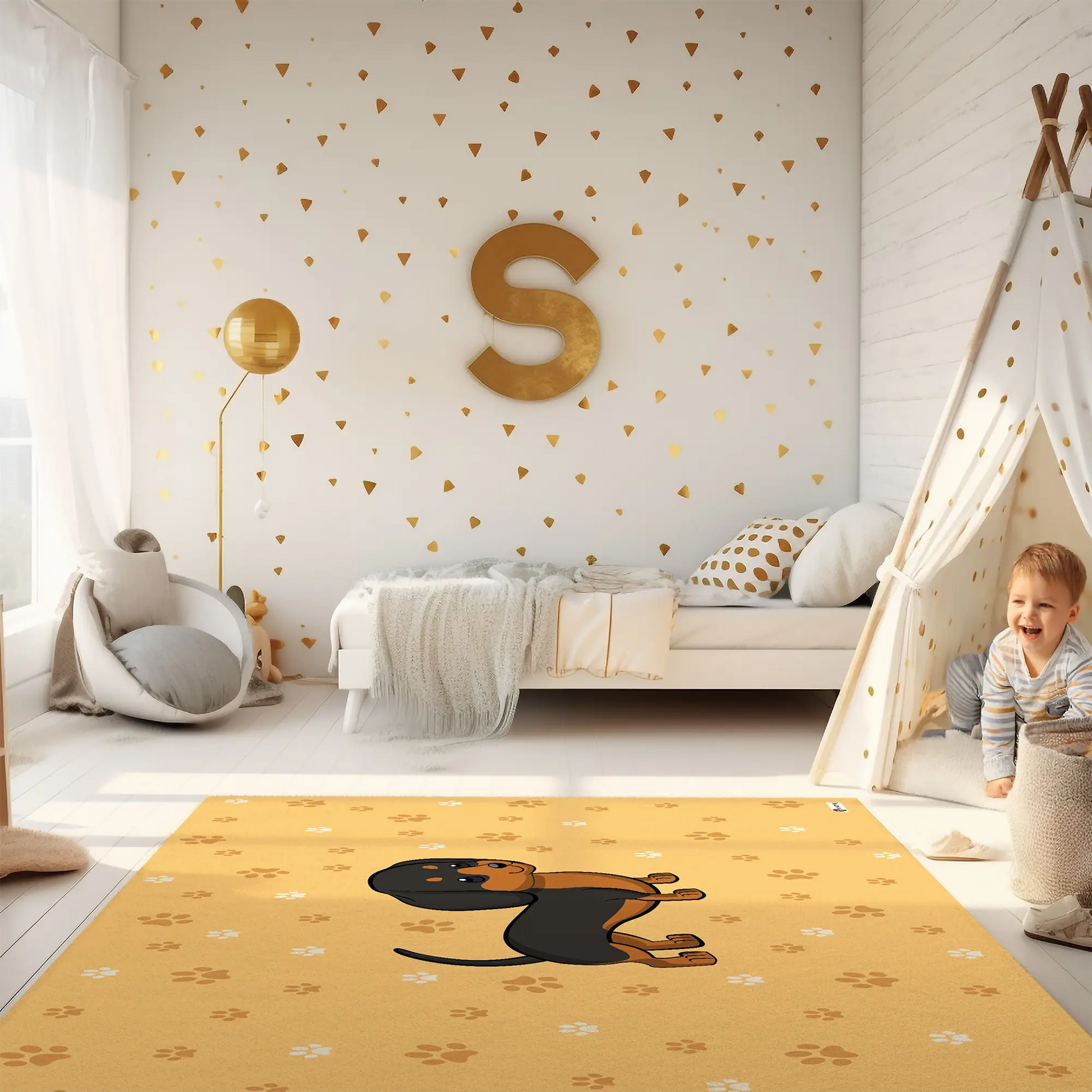 Kinderteppich "Danny Dackel" von spielzwerg. Ambientebild von einem hellen Kinderzimmer mit weißem Holzboden und weißen Wänden, dekoriert mit goldenen Dreiecken und einem großen goldenen Buchstaben 'S'. Links steht ein gemütlicher Sessel mit Kissen und Decke, daneben eine goldene Stehlampe. In der Mitte liegt der Teppich. Rechts sitzt ein lachender Junge in einem weißen Spielzelt mit goldenen Punkten. Im Hintergrund ein schlichtes Bett mit weißer Decke und goldenen Akzenten. RUG-00146-XL, RUG-00146-L.