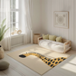 Kinderteppich "Guido Giraffe" von spielzwerg. Ambientebild von einem hellen, freundlichen Kinderzimmer mit weißen Holzwänden und hellem Holzboden. In der Ecke steht ein niedriges Holzbett mit weißen Decken und hellgrünen Kissen. Davor liegt der Teppich. Links steht ein kleines Holzspielzeugrad am Fenster mit weißen Vorhängen. An der Wand hängt ein gerahmtes Bild mit einem dezenten, kreisförmigen Muster. RUG-00057-XL, RUG-00057-L.