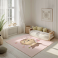 Kinderteppich "Iggy" von spielzwerg. Ambientebild von einem hellen, freundlichen Kinderzimmer mit weißen Holzwänden und hellem Holzboden. In der Ecke steht ein niedriges Holzbett mit weißen Decken und hellgrünen Kissen. Davor liegt der Teppich. Links steht ein kleines Holzspielzeugrad am Fenster mit weißen Vorhängen. An der Wand hängt ein gerahmtes Bild mit einem dezenten, kreisförmigen Muster. RUG-00025-XL, RUG-00025-L.