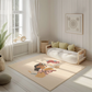 Kinderteppich "Selena" von spielzwerg. Ambientebild von einem hellen, freundlichen Kinderzimmer mit weißen Holzwänden und hellem Holzboden. In der Ecke steht ein niedriges Holzbett mit weißen Decken und hellgrünen Kissen. Davor liegt der Teppich. Links steht ein kleines Holzspielzeugrad am Fenster mit weißen Vorhängen. An der Wand hängt ein gerahmtes Bild mit einem dezenten, kreisförmigen Muster. RUG-00020-XL, RUG-00020-L.