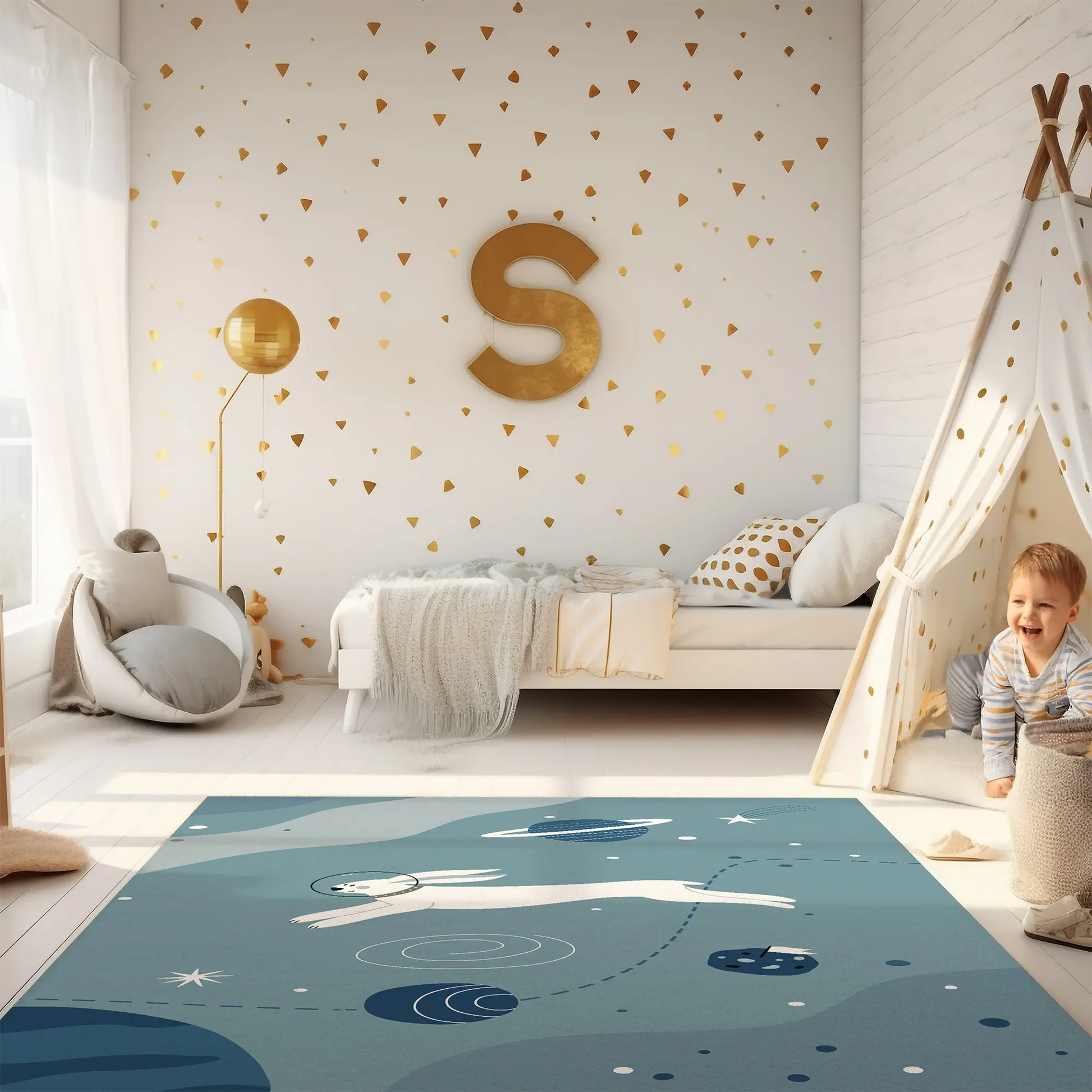 Kinderteppich "Hase im All" von spielzwerg. Ambientebild von einem hellen Kinderzimmer mit weißem Holzboden und weißen Wänden, dekoriert mit goldenen Dreiecken und einem großen goldenen Buchstaben 'S'. Links steht ein gemütlicher Sessel mit Kissen und Decke, daneben eine goldene Stehlampe. In der Mitte liegt der Teppich. Rechts sitzt ein lachender Junge in einem weißen Spielzelt mit goldenen Punkten. Im Hintergrund ein schlichtes Bett mit weißer Decke und goldenen Akzenten. RUG-00001-XL, RUG-00001-L.