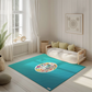 Kinderteppich "Sea Life" von spielzwerg. Ambientebild von einem hellen, freundlichen Kinderzimmer mit weißen Holzwänden und hellem Holzboden. In der Ecke steht ein niedriges Holzbett mit weißen Decken und hellgrünen Kissen. Davor liegt der Teppich. Links steht ein kleines Holzspielzeugrad am Fenster mit weißen Vorhängen. An der Wand hängt ein gerahmtes Bild mit einem dezenten, kreisförmigen Muster. RUG-00134-XL, RUG-00134-L.