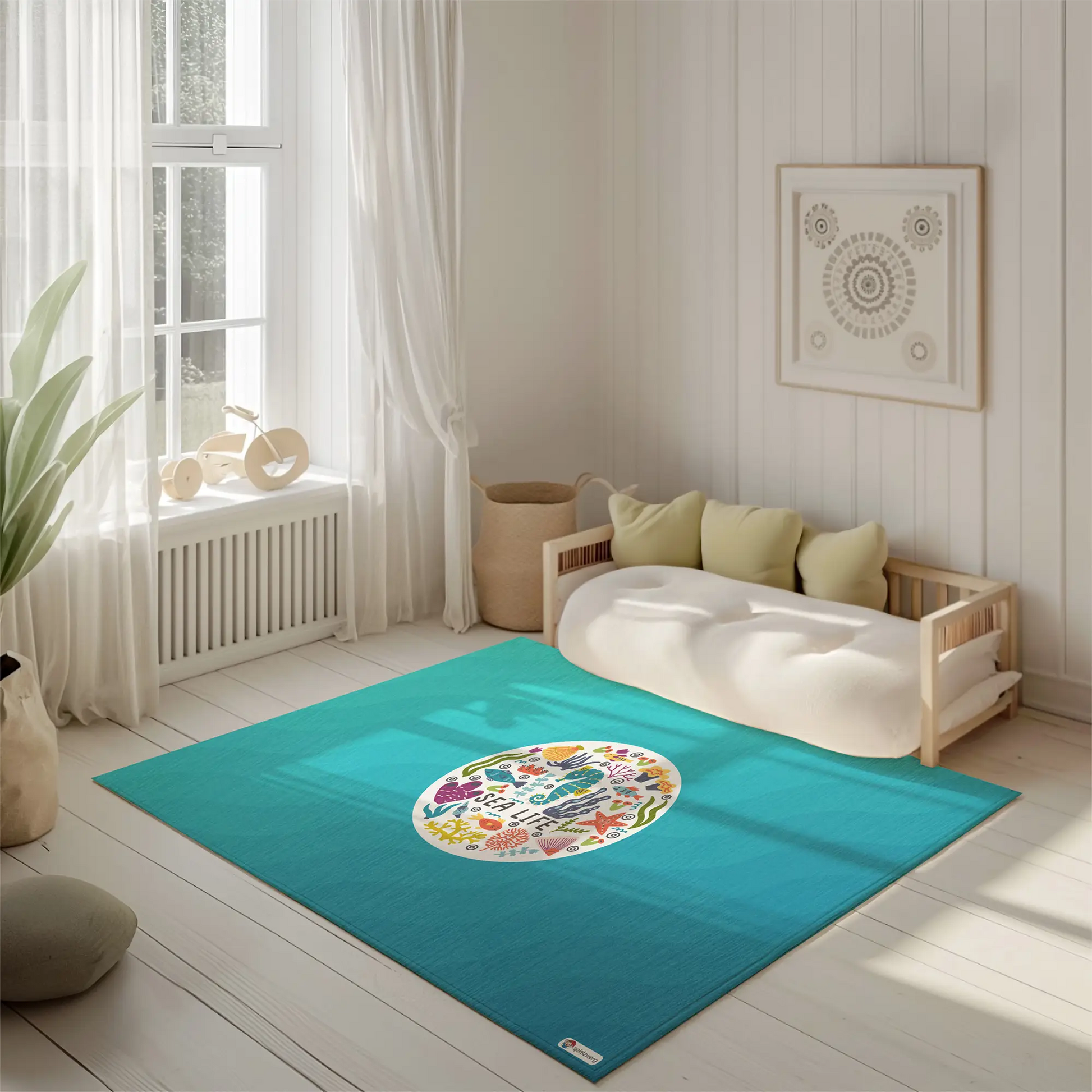Kinderteppich "Sea Life" von spielzwerg. Ambientebild von einem hellen, freundlichen Kinderzimmer mit weißen Holzwänden und hellem Holzboden. In der Ecke steht ein niedriges Holzbett mit weißen Decken und hellgrünen Kissen. Davor liegt der Teppich. Links steht ein kleines Holzspielzeugrad am Fenster mit weißen Vorhängen. An der Wand hängt ein gerahmtes Bild mit einem dezenten, kreisförmigen Muster. RUG-00134-XL, RUG-00134-L.