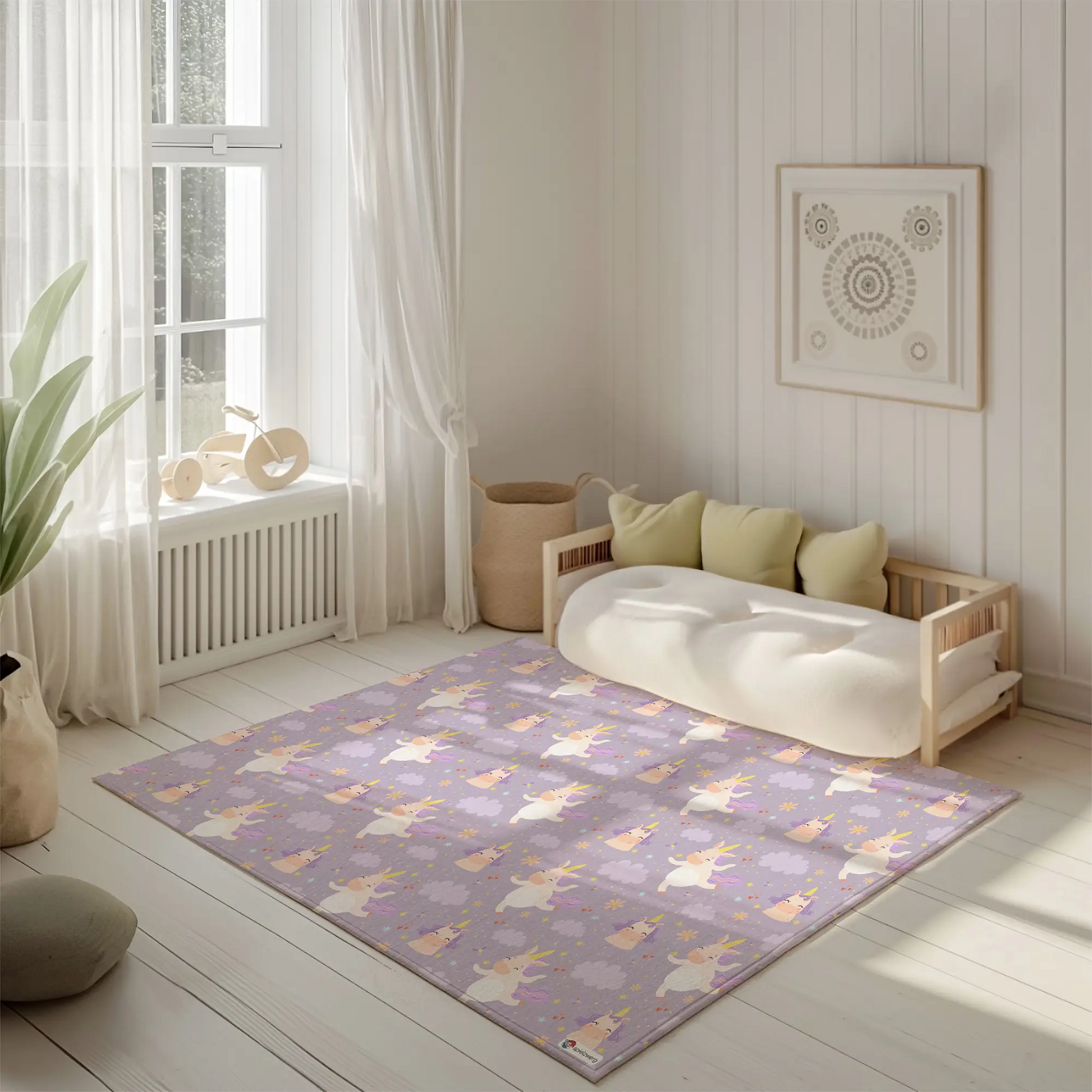 Kinderteppich "Einhornkür" von spielzwerg. Ambientebild von einem hellen, freundlichen Kinderzimmer mit weißen Holzwänden und hellem Holzboden. In der Ecke steht ein niedriges Holzbett mit weißen Decken und hellgrünen Kissen. Davor liegt der Teppich. Links steht ein kleines Holzspielzeugrad am Fenster mit weißen Vorhängen. An der Wand hängt ein gerahmtes Bild mit einem dezenten, kreisförmigen Muster. RUG-00111-XL, RUG-00111-L.